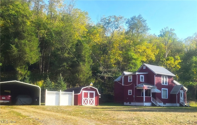 view of yard with a carport and a storage shed