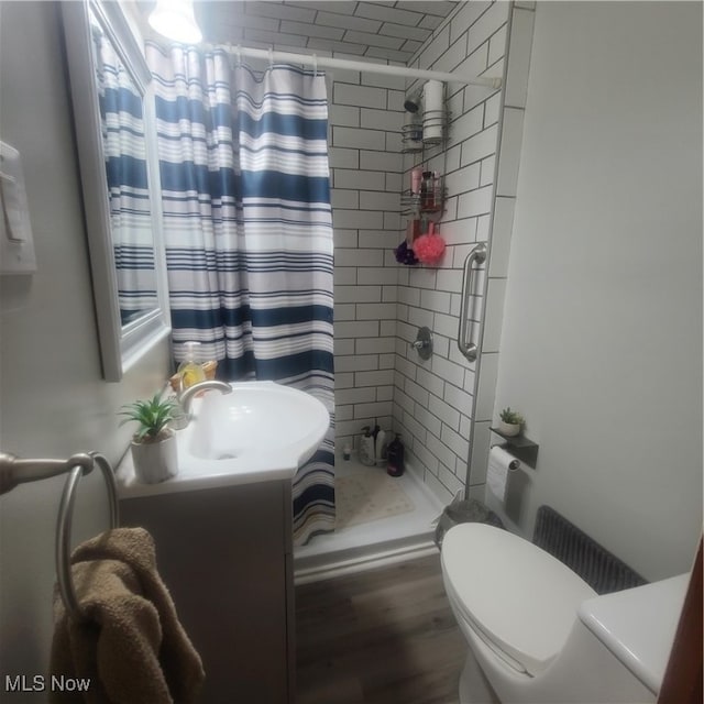 bathroom with curtained shower, hardwood / wood-style floors, toilet, and vanity