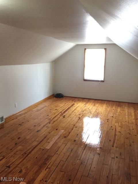 bonus room featuring vaulted ceiling and hardwood / wood-style floors