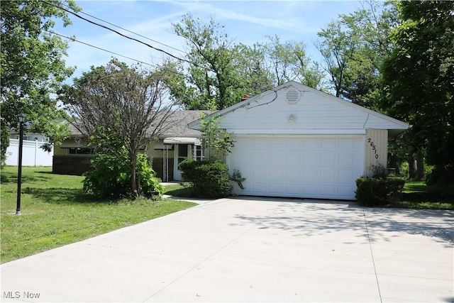 ranch-style house featuring a garage and a front lawn