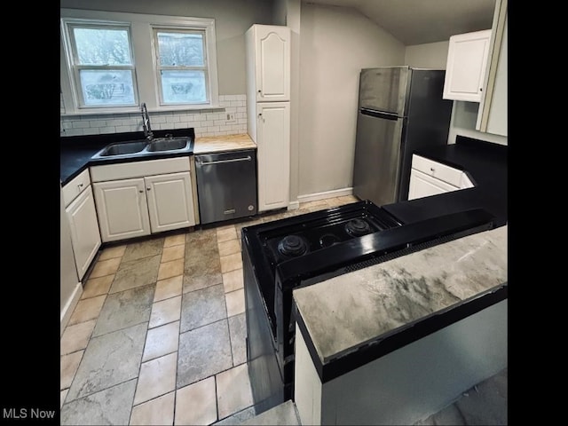 kitchen with stainless steel appliances, white cabinetry, sink, lofted ceiling, and decorative backsplash