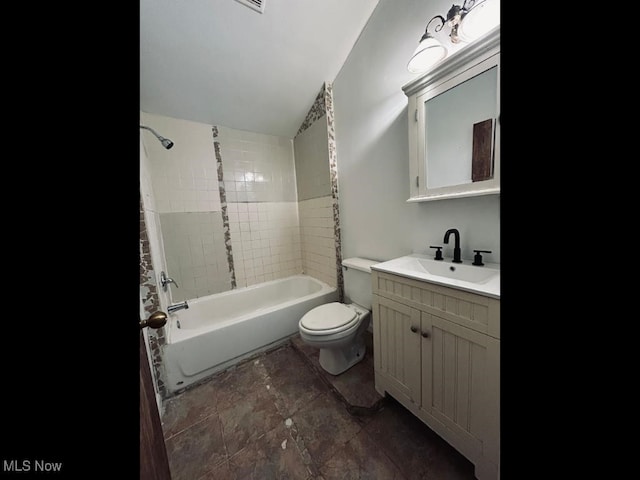 full bathroom with lofted ceiling, tiled shower / bath, toilet, and vanity