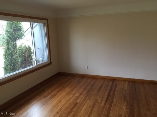 spare room with a healthy amount of sunlight and hardwood / wood-style floors