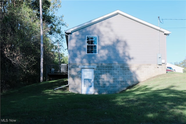 view of side of property with a deck, a lawn, and central AC unit