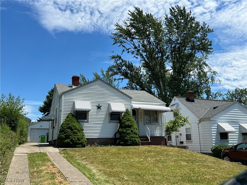 bungalow featuring a front yard and a garage