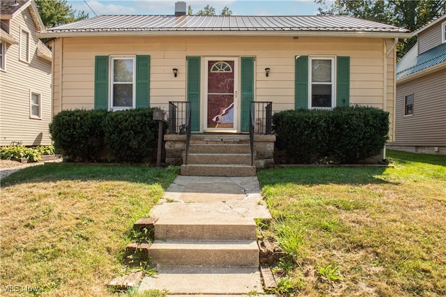 bungalow-style house featuring a front lawn