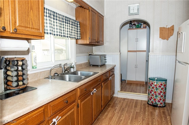 kitchen featuring light hardwood / wood-style flooring, sink, and white fridge