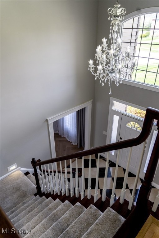 stairway with a high ceiling and an inviting chandelier