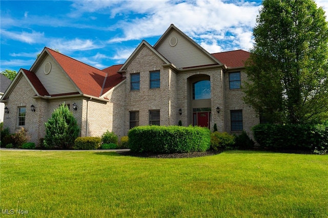 view of front of house with a front lawn and brick siding