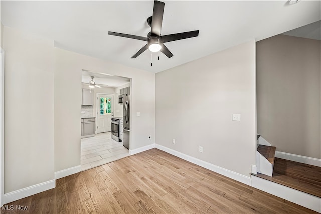 spare room with light wood-type flooring and ceiling fan