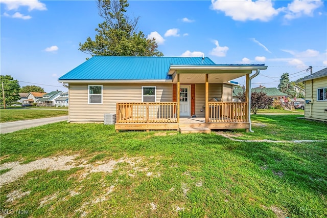 exterior space with a yard, a wooden deck, and central AC