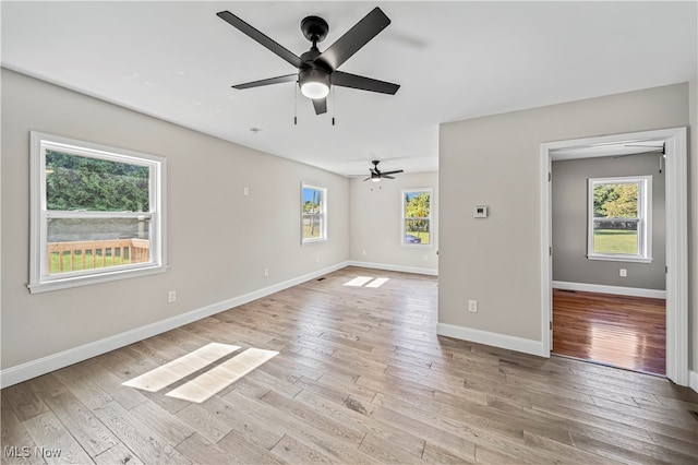 unfurnished room with light hardwood / wood-style floors, ceiling fan, and a wealth of natural light