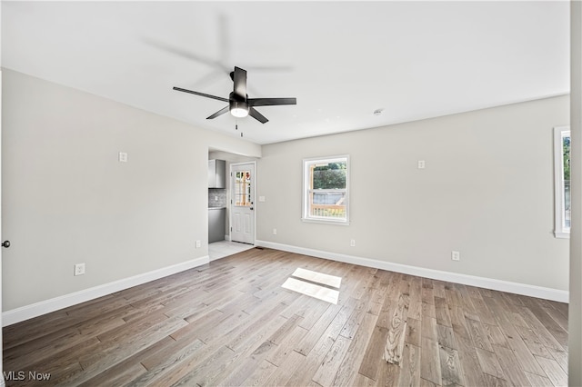 spare room with ceiling fan and light wood-type flooring