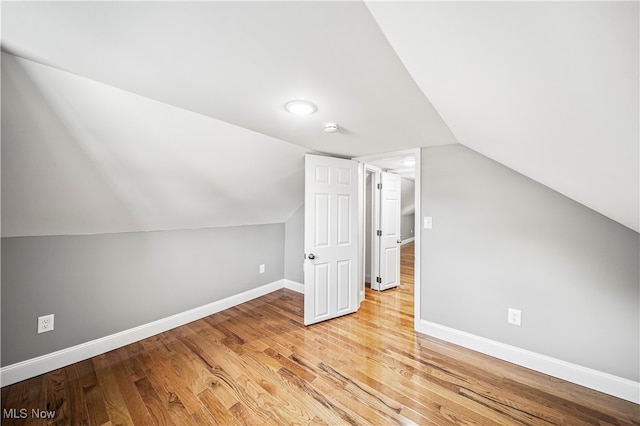 additional living space with vaulted ceiling and light hardwood / wood-style floors