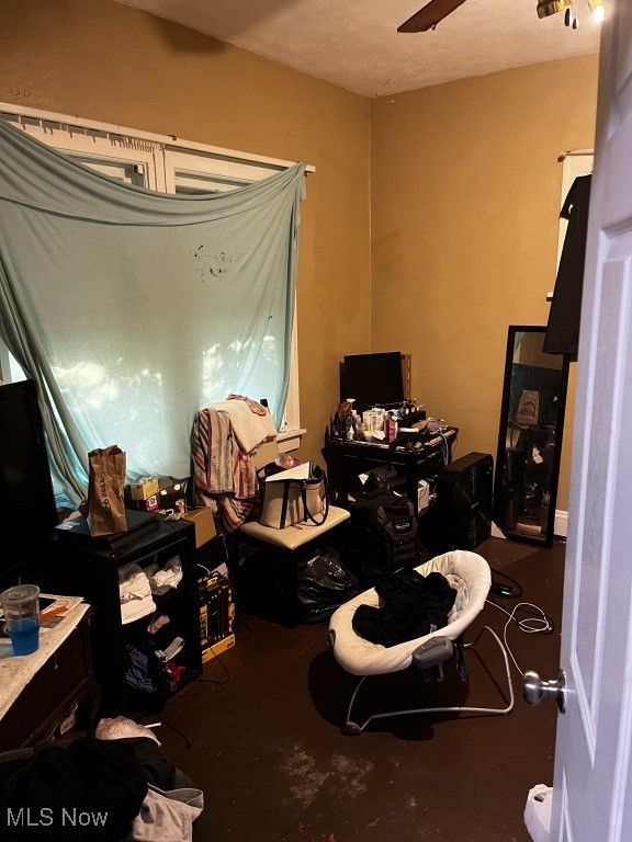 miscellaneous room with concrete flooring and ceiling fan