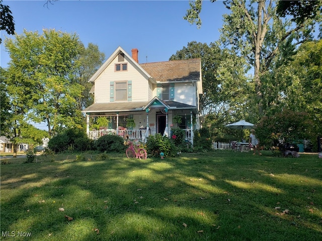 victorian house featuring a front yard and covered porch