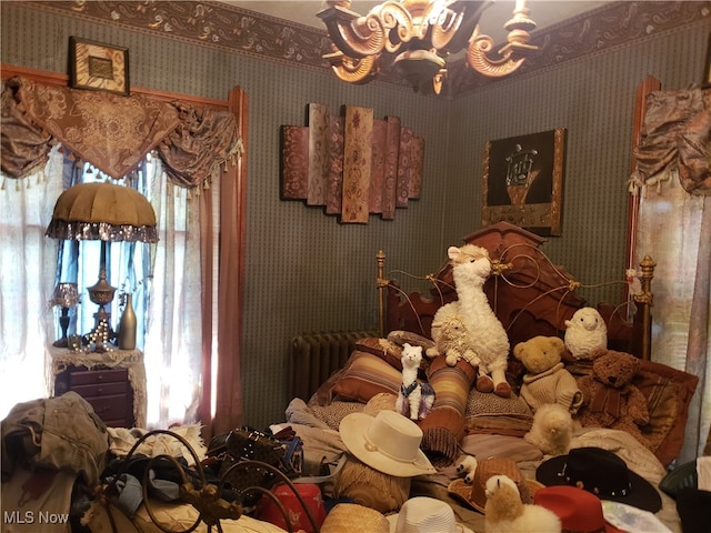 bedroom featuring radiator and a chandelier