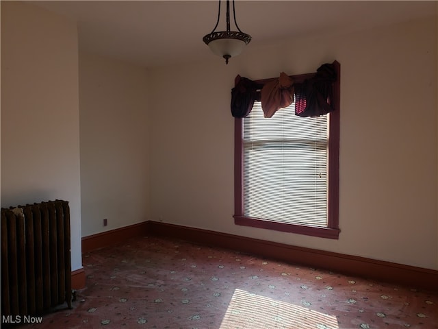 carpeted spare room with radiator and a wealth of natural light