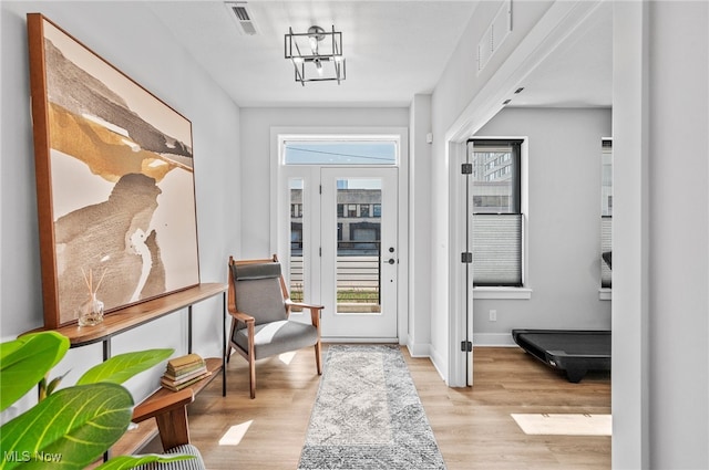 interior space featuring light hardwood / wood-style floors and a notable chandelier