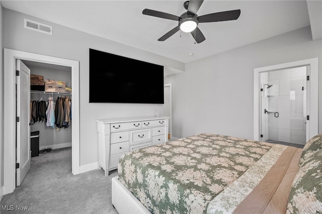 carpeted bedroom featuring a closet, ceiling fan, and a walk in closet