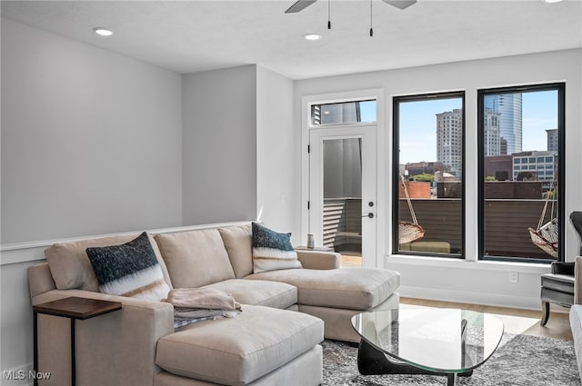 living room featuring a textured ceiling, wood-type flooring, and ceiling fan