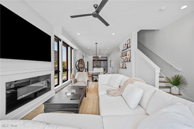 living room with light hardwood / wood-style floors and ceiling fan