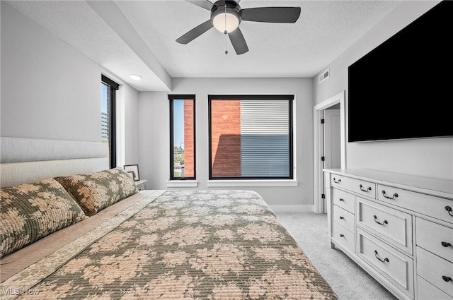 carpeted bedroom with a textured ceiling and ceiling fan