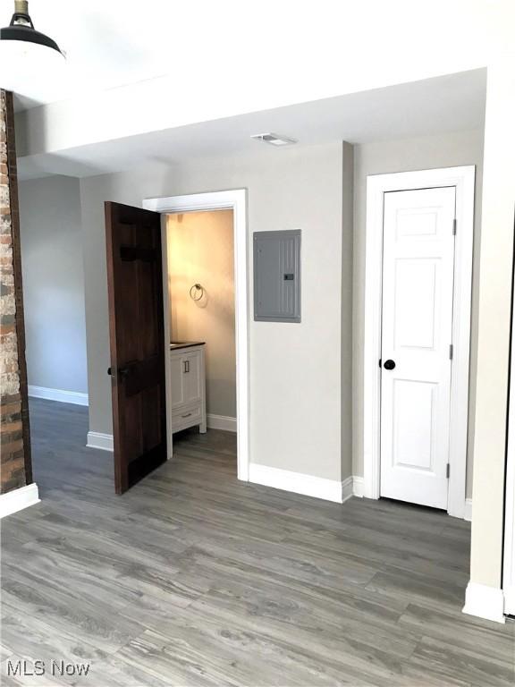 spare room featuring electric panel and hardwood / wood-style flooring