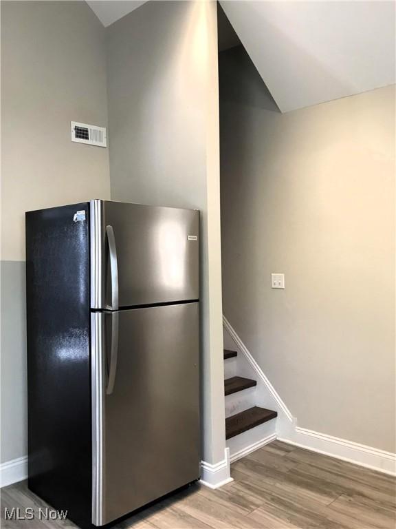 kitchen with hardwood / wood-style floors and stainless steel refrigerator