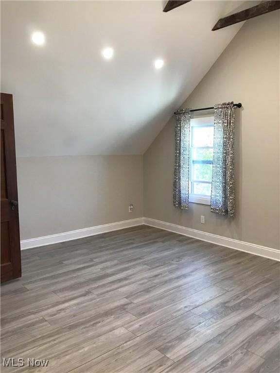 bonus room with vaulted ceiling and wood-type flooring