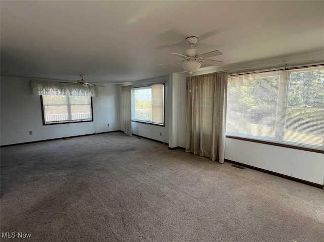 carpeted spare room featuring ceiling fan