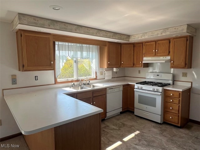 kitchen with white appliances, kitchen peninsula, and sink