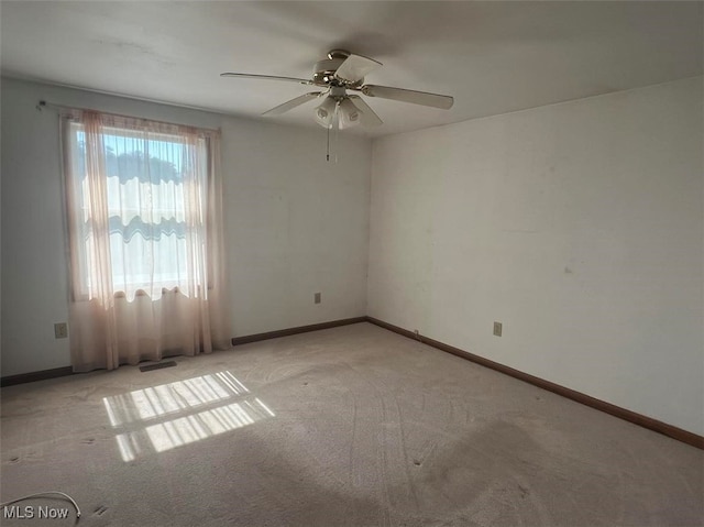 spare room featuring ceiling fan and light colored carpet