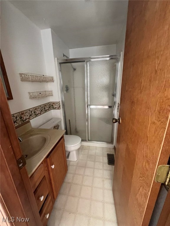 bathroom with vanity, toilet, and an enclosed shower