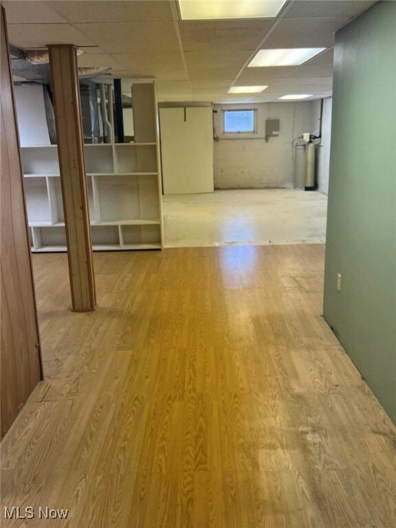 basement featuring hardwood / wood-style floors and a drop ceiling