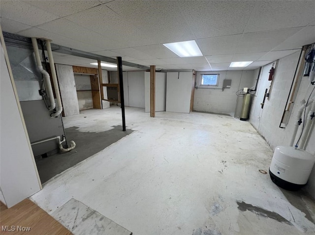 basement featuring heating unit and a drop ceiling