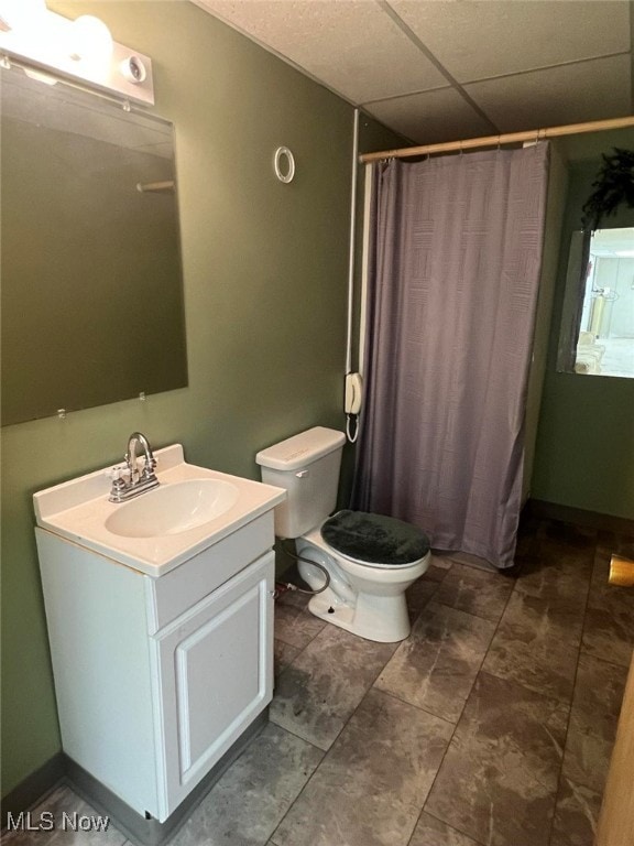 bathroom featuring a paneled ceiling, toilet, a shower with shower curtain, and vanity