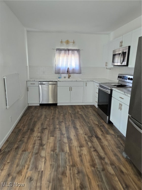 kitchen with white cabinets, appliances with stainless steel finishes, sink, and dark hardwood / wood-style floors