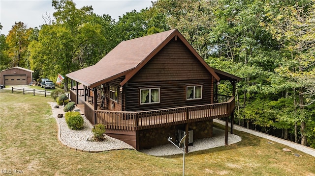 rear view of house with central air condition unit, a lawn, an outdoor structure, a garage, and a wooden deck