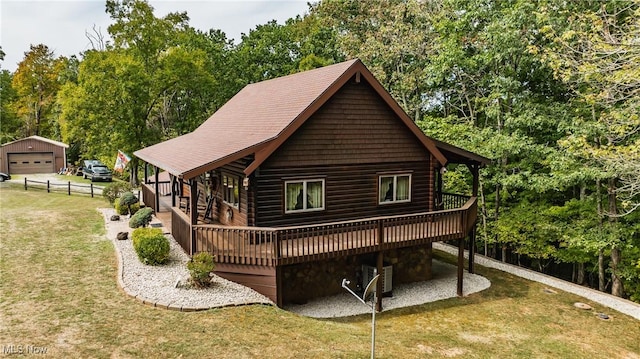 2207 Veto Rd, Vincent, OH 45784 - rear view of house featuring a deck, a yard, a detached garage, and faux log siding