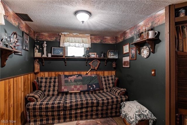 interior space with wood walls and a textured ceiling