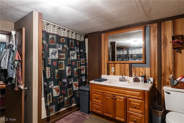 bathroom featuring toilet, a textured ceiling, and vanity