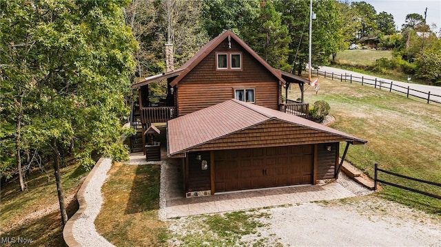 2207 Veto Rd, Vincent, OH 45784 - view of front facade featuring a garage, stairway, log veneer siding, and gravel driveway
