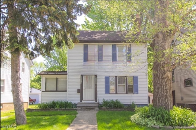 colonial home featuring a front lawn