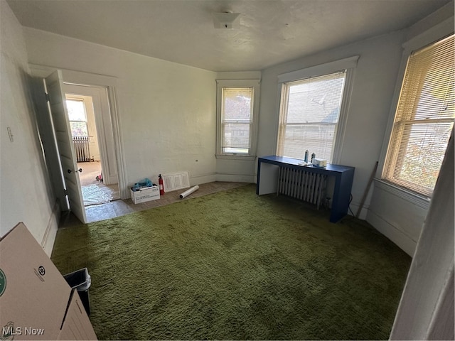 spare room with carpet and radiator heating unit