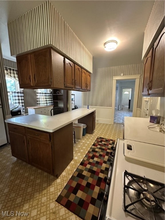 kitchen with dark brown cabinetry, a kitchen breakfast bar, and kitchen peninsula