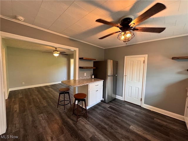 kitchen featuring dark hardwood / wood-style flooring, white cabinetry, ceiling fan, and stainless steel fridge