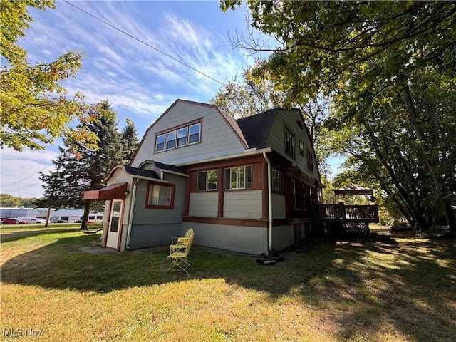 view of side of property featuring a deck and a yard