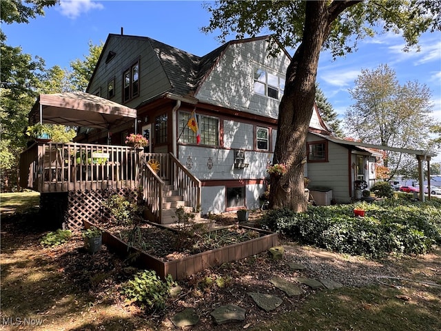 rear view of property featuring a wooden deck