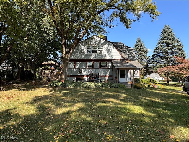 rear view of house with a deck and a lawn